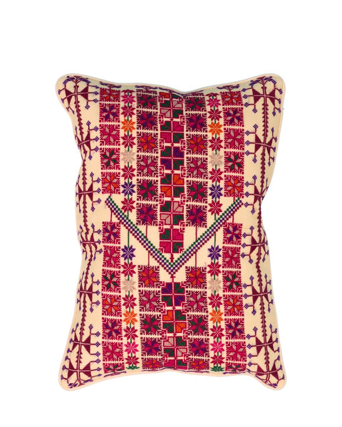 A square decorative throw pillow with a cream-colored base and intricate, colorful geometric embroidery in red, pink, purple, and green.